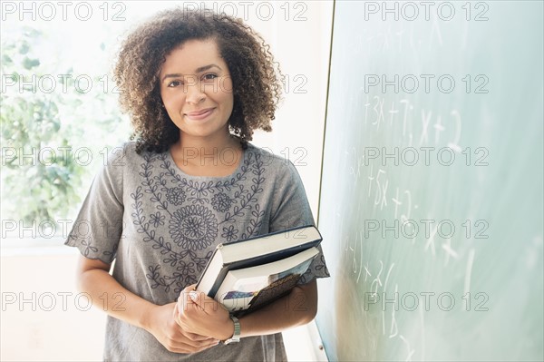 Portrait of young woman holding books.