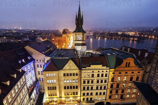 Old town tower by Vltava River at sunset