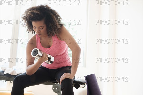 Young woman training with dumbbells.