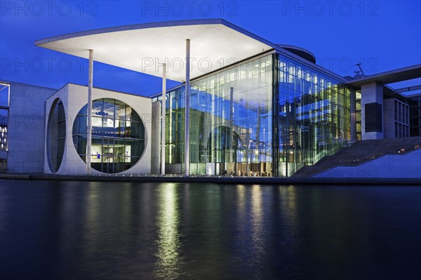 Riverfront parliament office building illuminated at dusk