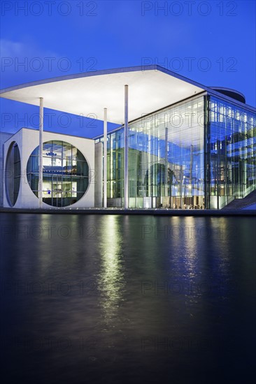 Riverfront parliament office building illuminated at dusk