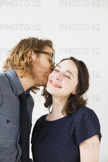 Man kissing smiling young woman