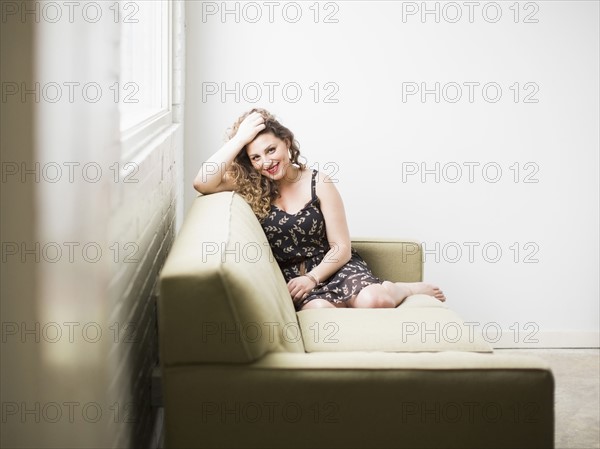 Smiling woman sitting on sofa