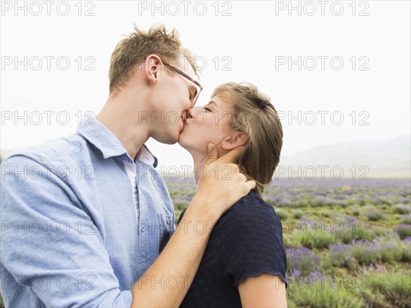 Young couple kissing with field on background