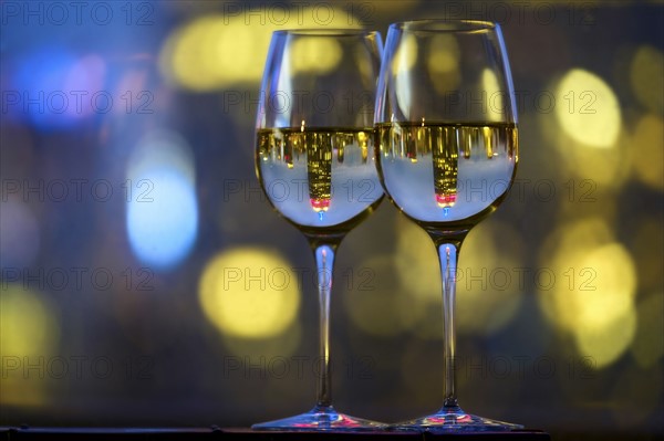 Two wineglasses with white wine. USA, New York, New York City.