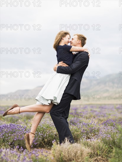 Newlywed couple embracing in lavender field