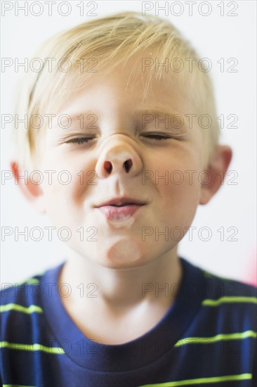 Boy (2-3) making funny face behind window