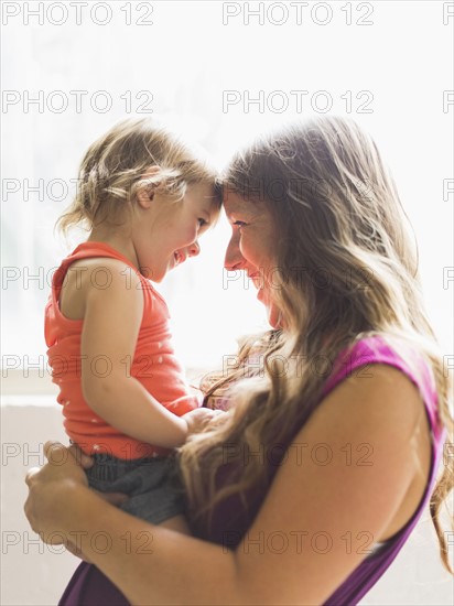 Mather carrying daughter (2-3) and smiling