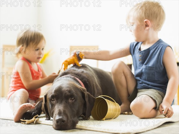 Children (2-3) playing with dog