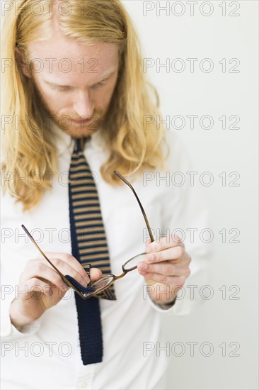 Blond man wiping glasses