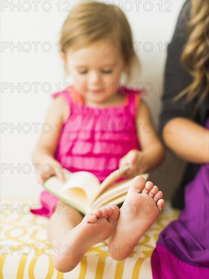 Little girl (2-3) holding book