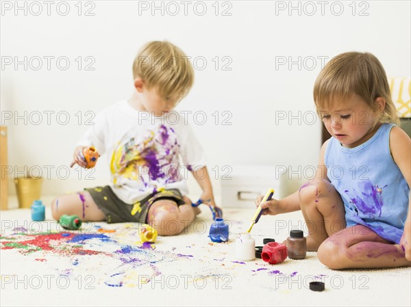 Children (2-3) painting on carpet