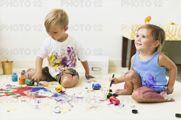 Children (2-3) painting on carpet