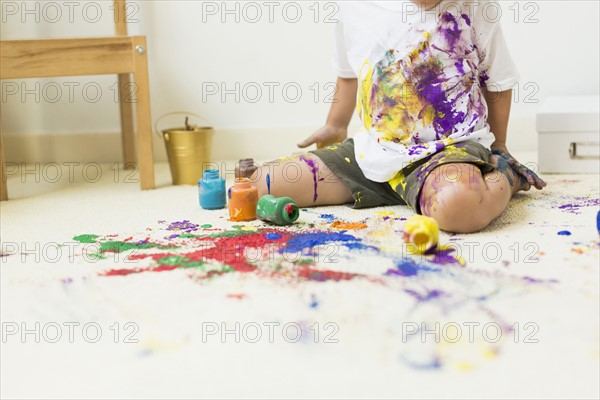 Boy (2-3) painting on carpet