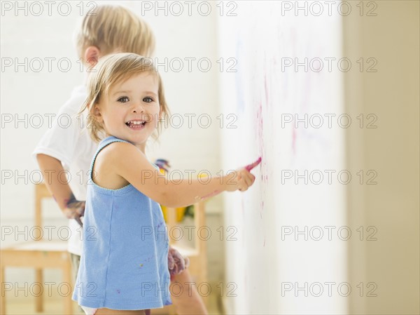 Children (2-3) painting on wall