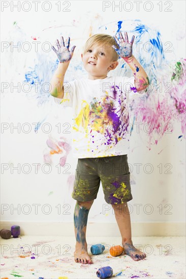 Boy (2-3) showing hands after painting on wall