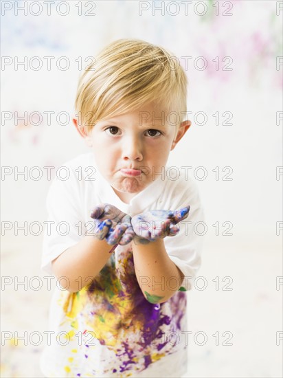 Boy (2-3) showing hands in paint