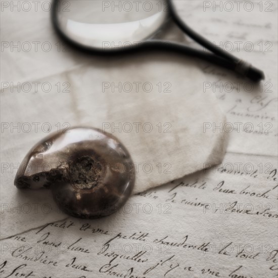 Old magnifying glass, shell and letters.