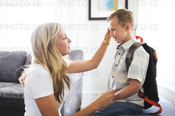 Mother preparing son (6-7) for school