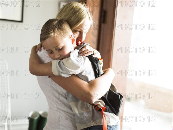 Mother hugging son (6-7)