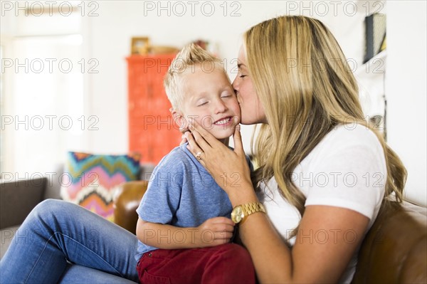 Mother kissing son (4-5)