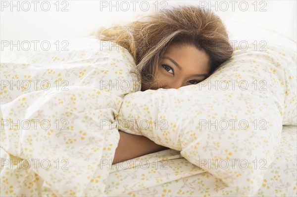 Young woman lying in bed.