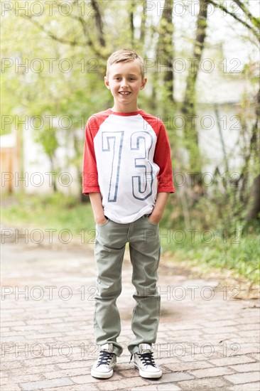 Portrait of boy (6-7) standing on sidewalk