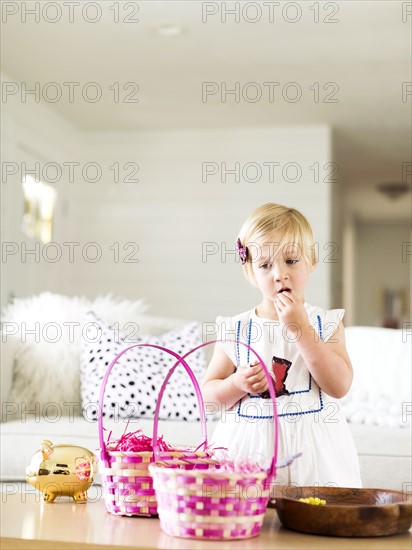 Girl (2-3) eating candy in living room