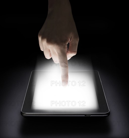 Woman touching digital tablet in studio.