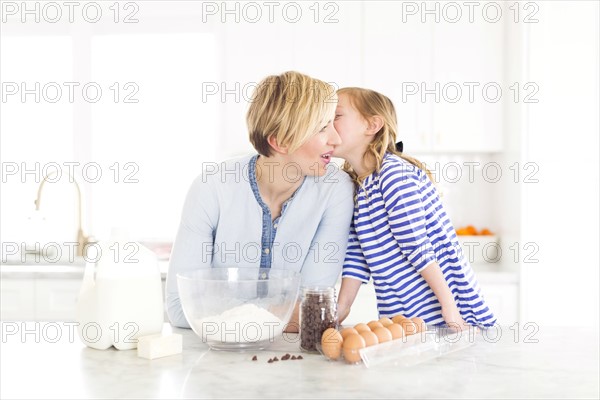 Girl (4-5) whispering into mom's ear