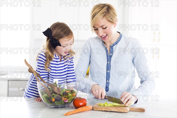 Mother and daughter (4-5) preparing salad