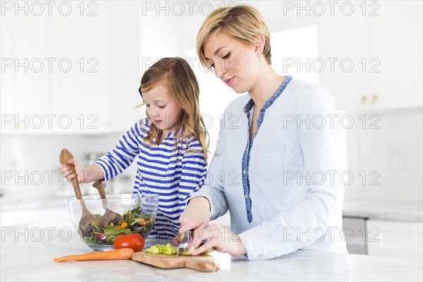 Mother and daughter (4-5) preparing salad