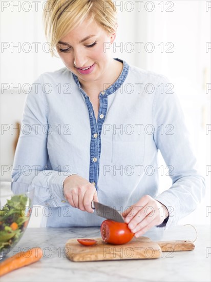 Mid-adult woman preparing salad