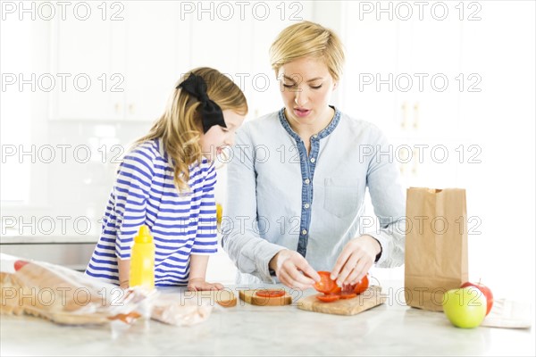 Mother making sandwiches for her daughter (4-5)