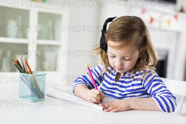 Girl (4-5) drawing in living room