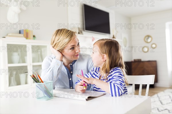 Girl (4-5) drawing with her mom
