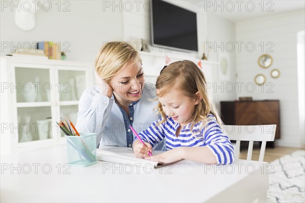 Girl (4-5) drawing with her mom