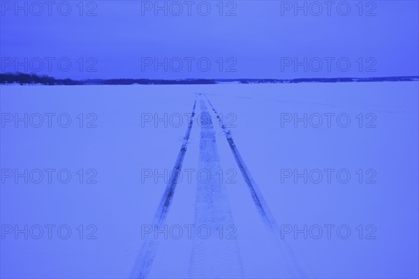 Snowmobile tracks on frozen lake