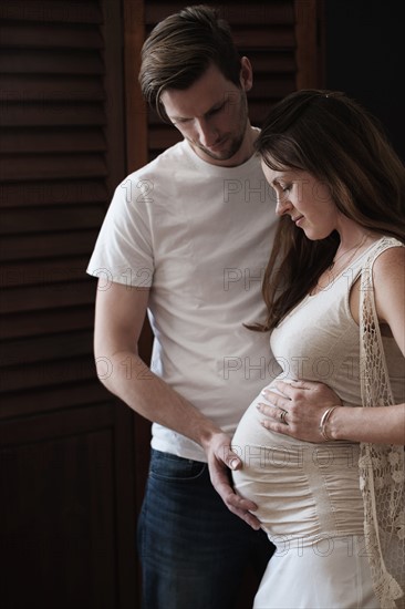 Man touching woman's abdomen.