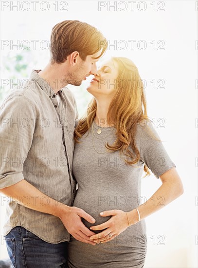 Mid-adult couple kissing outdoors.