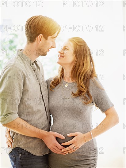 Mid-adult couple face to face outdoors.