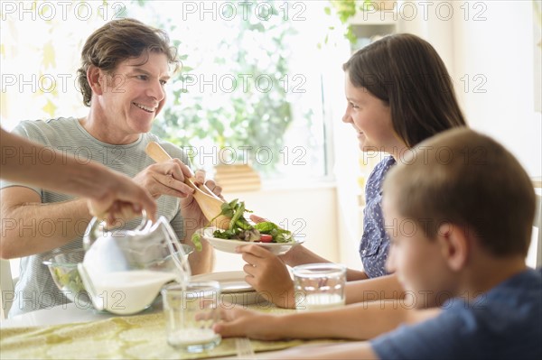 Children (8-9, 10-11) eating salad with parents.