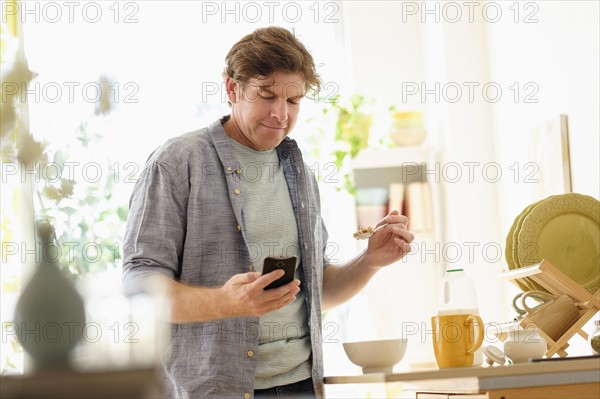 Man texting and eating.