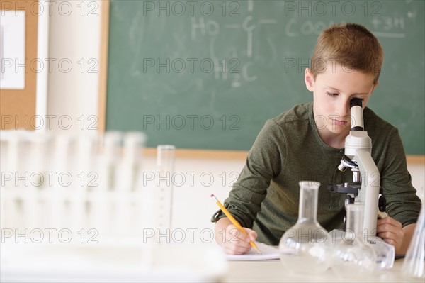 Boy (8-9) looking through microscope.