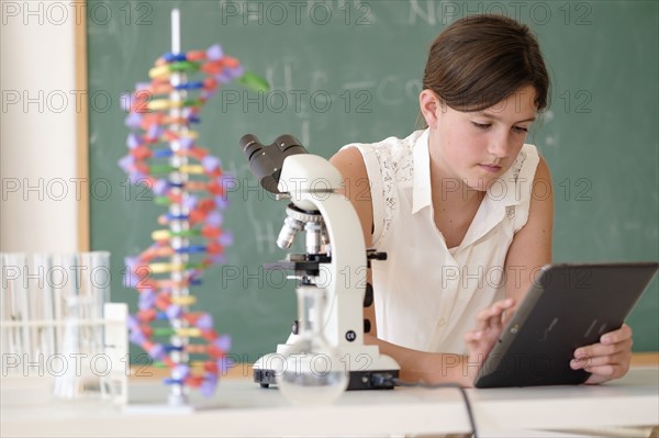 Girl (10-11) using tablet pc in classroom.