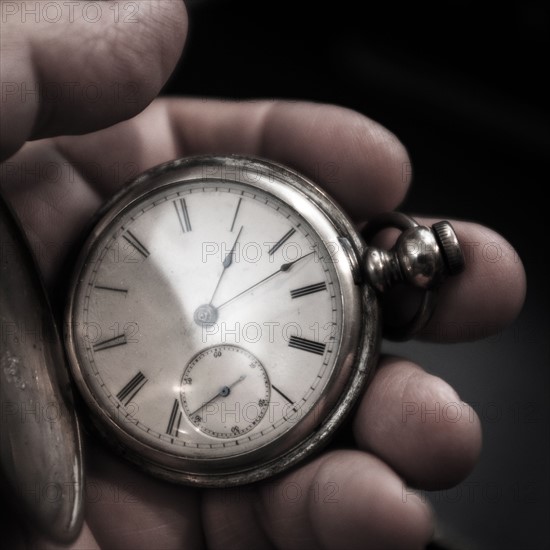 Pocket watch in man's hand.