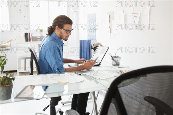 Mid-adult man working in office.