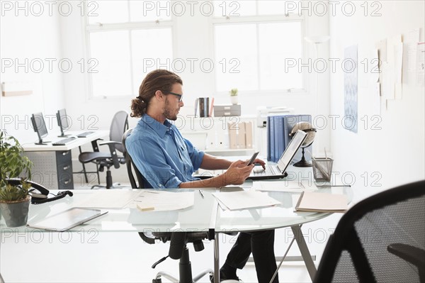 Mid-adult man working in office.