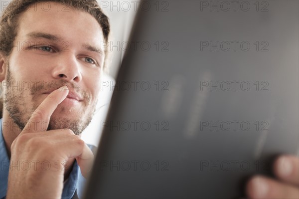 Mid-adult man using tablet pc.