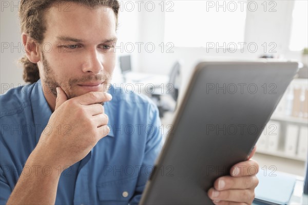 Mid-adult man using tablet pc.